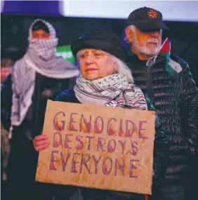  ?? (Adam Gray/Reuters) ?? A WOMAN holds a placard accusing Israel of committing genocide as she attends a vigil for US Airman Aaron Bushnell in New York, this week.