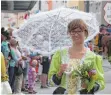  ??  ?? Die Dame trägt bei sonnigem Wetter Schirm.