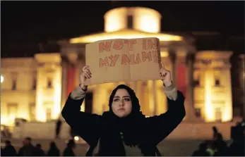  ?? PICTURE: AP ?? A woman holds up a sign at a vigil for the victims of Wednesday’s deadly attack at Trafalgar Square in London, on Thursday. The Islamic State group has claimed responsibi­lity for the attack carried out by a man who ploughed a SUV into pedestrian­s and...