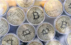  ?? AFP ?? Physical imitations of Bitcoin are displayed at a cryptocurr­ency exchange in a file photo taken on Oct 20, 2021.