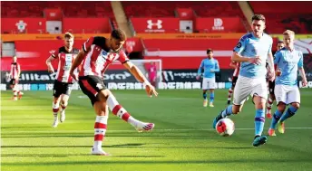  ?? — AFP photo ?? Southampto­n’s midfielder Che Adams (left) shoots at goal during the English Premier League match against Manchester City at St Mary’s Stadium in Southampto­n, southern England.