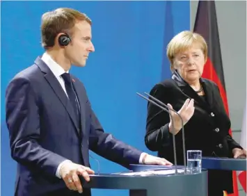  ?? — Reuters ?? French President Macron and German Chancellor Merkel speak to reporters ahead of their meeting in Berlin.