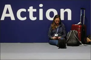  ?? The Associated Press ?? CLIMATE SUMMIT: A woman sits on the floor looking at her phone a day before the start of the COP25 Climate summit in Madrid, Spain, on Sunday. This year’s internatio­nal talks on tackling climate change were meant to be a walk in the park compared to previous instalment­s. But with scientists issuing dire warnings about the pace of global warming and the need to urgently cut greenhouse gas emissions, officials are under pressure to finalize the rules of the 2015 Paris accord and send a signal to anxious voters.