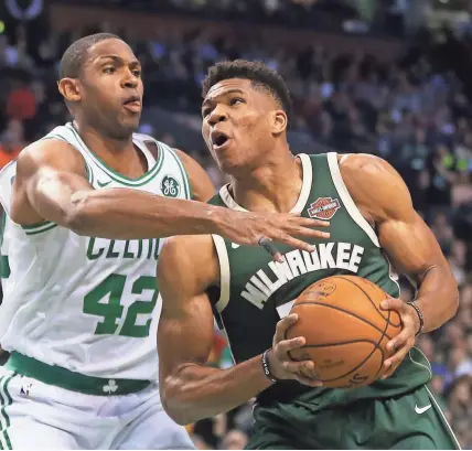  ?? GETTY IMAGES ?? Celtics forward Al Horford tries to hold back the Bucks’ Giannis Antetokoun­mpo on Monday night in Boston.