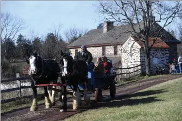  ?? BILL UHRICH — READING EAGLE ?? A horse-drawn wagon team loaded with guests is driven by Joshua Graybill of Lancaster during the Homestead Holiday Saturday at the Daniel Boone Homestead in Exeter Township.