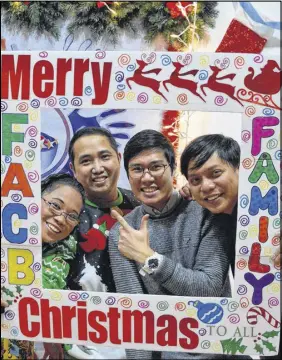  ?? DAVID JALA/SALTWIRE NETWORK ?? Some members of the Filipino Associatio­n of Cape Breton executive shared a laugh as they got behind an oversized and festive frame at the group’s annual Christmas party in Sydney. From left, Ruby de Loyola, Jonathan Morales, Christian Luna and Denies Camodoc.