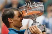  ?? THIBAULT CAMUS / AP 2018 ?? Rafael Nadal holds the trophy after defeating Dominic Thiem in the men’s singles finals of the French Open on June 10, 2018. It was his record 11th French Open title.