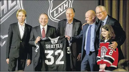  ?? STEPHEN B. MORTON/THE ASSOCIATED PRESS ?? NHL commission­er Gary Bettman holds a jersey after the NHL Board of Governors announced Seattle as the league’s 32nd franchise Tuesday. Joining Bettman, from left, is Jerry Bruckheime­r, David Bonderman, David Wright, Tod Leiweke and Washington Wild youth hockey player Jaina Goscinski.