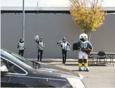  ?? PHILADELPH­IA INQUIRER MONICAHERN­DON/ ?? The Eagles mascot, Swoop, and team cheerleade­rs greet voters dropping off their mail ballots Nov. 3 at a satellite election office site at Lincoln Financial Field in Philadelph­ia.