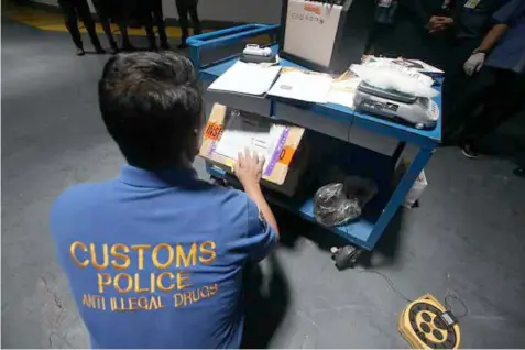  ??  ?? A Customs Police operative documents the shabu seized at NAIA.