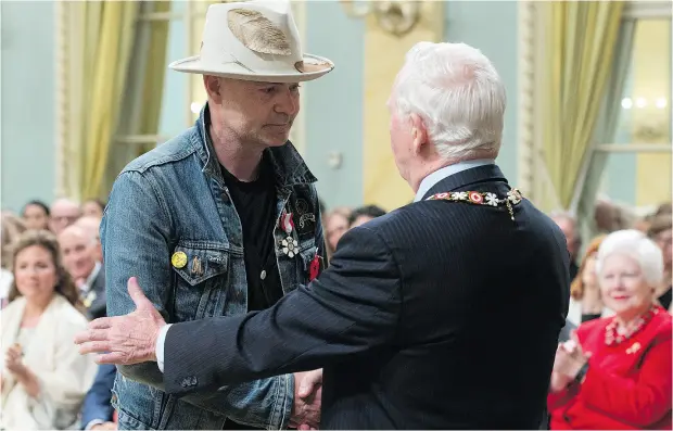  ?? ADRIAN WYLD / THE CANADIAN PRESS ?? Governor General David Johnston shakes hands with Tragically Hip singer Gord Downie after investing him in the Order of Canada during a ceremony at Rideau Hall Monday. During the event, he also apologized for earlier calling First Nations people...