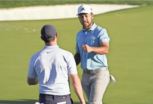  ?? PHOTOS BY ROB SCHUMACHER/THE REPUBLIC ?? Xander Schauffele, facing, meets with playing partner Rory McIlroy after finishing Friday’s second round of the Waste Management Phoenix Open at TPC Scottsdale. Schauffele shot 64 to take a one-shot lead after 36 holes.