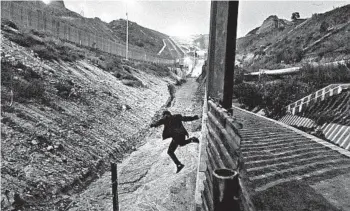  ?? DANIEL OCHOA DE OLZA/AP ?? A change by the administra­tion is affecting young migrants fleeing abuse. Above, a youth jumps from the border fence.