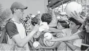  ?? AL DIAZ adiaz@miamiheral­d.com ?? Jannik Sinner of Italy autographs a hat for fans after defeating Tomas Machac of the Czech Republic during the Miami Open Tennis Tournament on Wednesday.