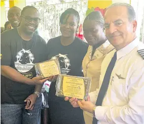  ??  ?? The presidents of the Caribbean Employees Resource Group in London and Miami being presented with a plaque. This group planned the Adopt an Island trip to Jamaica.