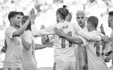  ??  ?? Real Madrid’s Welsh forward Gareth Bale (C) celebrates a goal with teammates during the Spanish League football match between UD Las Palmas and Real Madrid CF at the Gran Canaria stadium in Las Palmas on March 31, 2018. - AFP photo