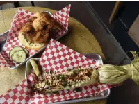  ??  ?? Fried chicken and biscuit sandwich with a side of Colorado street corn at The Coop Chicken + Beer.