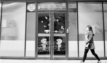  ??  ?? A woman walks past the closed Ctrip day-care centre in Shanghai. — AFP photo