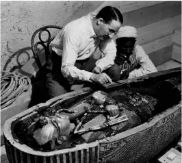  ?? ?? Howard Carter and an Egyptian colleague examine the inner coffin