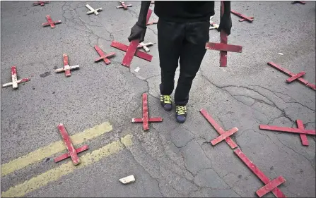  ??  ?? On a Nairobi, Kenya, street, crosses symbolize dozens of non-Muslims killed in an attack on a bus in Mandera last year by Somali militant group al-Shabab. Kenya’s police force said 174 people were killed by Islamic extremists in 2014, the highest...