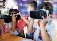  ?? WANG PENG / XINHUA ?? Primary school students from Yinchuan, the Ningxia Hui autonomous region, experience VR headsets on June 29.