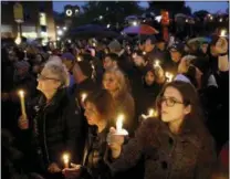  ?? AP PHOTO/MATT ROURKE ?? People hold candles as they gather for a vigil in the aftermath of a deadly shooting at the Tree of Life Congregati­on in Pittsburgh on Saturday.