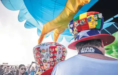  ?? ROBERTO E. ROSALES/JOURNAL ?? Visitors at the Balloon Fiesta display their collection­s of pins on festive hats during a mass ascension of the 2019 Albuquerqu­e Internatio­nal Balloon Fiesta.