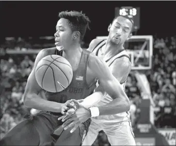  ?? Jae C. Hong Associated Press ?? JORDAN McLAUGHLIN knocks the ball away from Stanford’s Kezie Okpala during the first half.