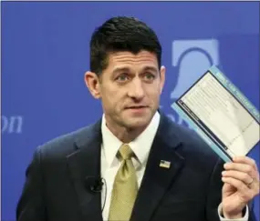  ?? SUSAN WALSH — THE ASSOCIATED PRESS ?? House Speaker Paul Ryan of Wis., holds up a copy of a proposed “simple tax” postcard while speaking at the Heritage Foundation in Washington, Thursday.