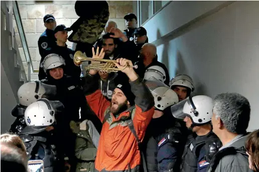  ?? AP ?? Serbian police officers remove demonstrat­ors from the state-run TV headquarte­rs in Belgrade.