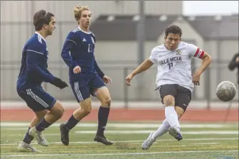  ?? ?? (Left) Valencia captain Azael Jovel (11) gets past West Ranch defenders to score a goal in the first half during a Foothill league match at West Ranch High School on Thursday. (Right) Valencia winger Rami Maroun (7) and West Ranch midfielder Andrew Montes (7) battle for the ball.