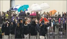  ?? LAURA A. ODA — STAFF PHOTOGRAPH­ER ?? Parishione­rs and students from St. Joseph’s Elementary and High Schools brave the rain to watch the blessing of the newly installed bell tower cross at St. Joseph Basilica in Alameda on Thursday.