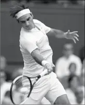  ?? ASSOCIATED PRESS ?? SWITZERLAN­D’S Roger Federer returns the ball to Slovakia’s Lukas Lacko during their men’s singles match on the third day of the Wimbledon Tennis Championsh­ips in London, Wednesday.