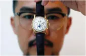  ?? Reuters ?? An exhibitor displays a gold perpetual chronograp­h watch at the Christie’s in Dubai.