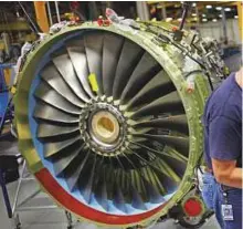  ?? AFP ?? A mechanic installs a bracket on a CFM56-7 jet engine at a factory in Cincinnati, Ohio.