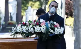  ??  ?? Funeral workers transport the coffin of a coronaviru­s victim into a cemetery in Bergamo. Photograph: Flavio Lo Scalzo/Reuters