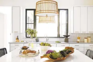  ?? ARTERIORS ?? Atlanta designer Beth Webb’s Sea Island pendants have a beachy vibe, recalling the humble yet complex structure of a wicker basket. The linen-wrapped drum has a rattan structure and hangs like a birdcage from the ceiling.