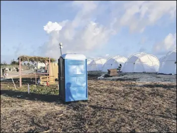  ?? JAKE STRANG VIA AP ?? Tents and a portable toilet set up for attendees for the Fyre Festival, Friday in the Exuma islands, Bahamas. Organizers of the much-hyped music festival in the Bahamas canceled the weekend event at the last minute Friday after many people had already...