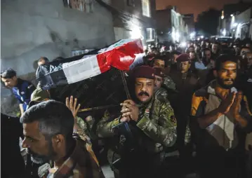  ?? (Marcus Yam/Los Angeles Times/TNS) ?? MOURNERS MARCH in Baghdad in March with the casket for the funeral for Mustafah, a friend of Wissam Daoud and fellow Iraqi bomb diffuser, on the same day Daoud went to Najaf to visit friends who perished in the fight against ISIS.