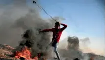  ??  ?? A Palestinia­n protester hurls stones towards Israeli soldiers near the Gaza Strip border with Israel.