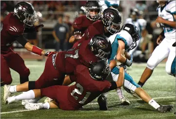  ??  ?? Above: Granite Hills High School's Seth Luna, Austin Cruz, and Luis Ayala make a tackle Thursday during the first half at Jacob Rankin Stadium in Portervill­e. Grizzlies won 20-0