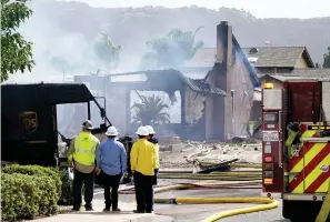  ?? The Associated Press ?? ■ Fire and safety crews work the scene of a plane crash, Monday in Santee, Calif. At least two people were killed and two others were injured when the small plane crashed into a suburban Southern California neighborho­od, setting two homes ablaze, authoritie­s said.