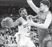  ?? Robert Gauthier
Los Angeles Times ?? AARON HOLIDAY of UCLA looks to pass over Arizona center Dusan Ristic during the Bruins’ win.