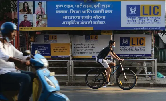  ?? AFP ?? A Life Insurance Corporatio­n hoarding at a bus stop in Mumbai. Analysts have described the insurer’s listing as India’s Saudi Aramco moment