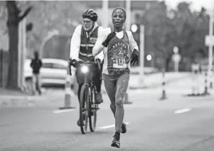  ?? JUNFU HAN/DETROIT FREE PRESS ?? Beasley makes her way into the Woodbridge neighborho­od during the 45th Annual Detroit Free Press Marathon on Sunday. She finished in 2:42:25.