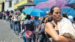  ??  ?? TRAGIC REALITY: People queue to buy basic food items in Caracas