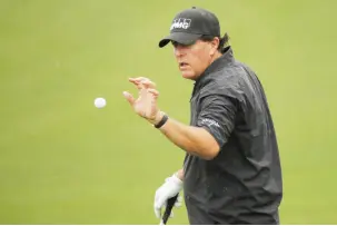  ?? — Reuters photo ?? Mickelson warms-up on the driving range in inclement weather during the second day of practice.