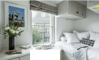  ??  ?? Left Neutral walls, bedding and cupboards are offset by colourful artwork. Above Generous wardrobe storage with a two-seater sofa, which is in front of a hidden, pull-down spare bed. Above leftBespok­e cupboards on either side of the fireplace conceal an oven and fridge