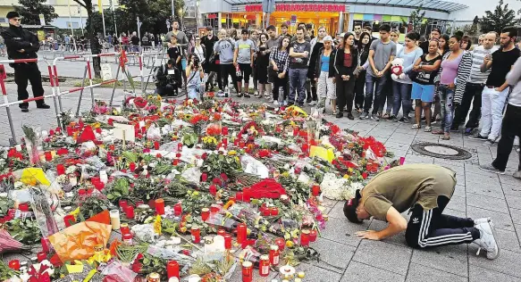  ?? Foto: Reuters ?? Pieta Lidé přišli k nákupnímu centru v Mnichově uctít památku obětí vraha. V pátek večer tady David Sonboly zastřelil devět náhodně vybraných lidí.