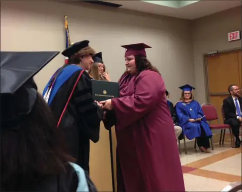  ?? Contribute­d. ?? . Graduation: Cynthia Landaverde is pictured getting her GED diploma binder from SouthArk president Dr. Barbara Jones at graduation.